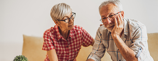 Senior couple sitting on couch having a serious discussion